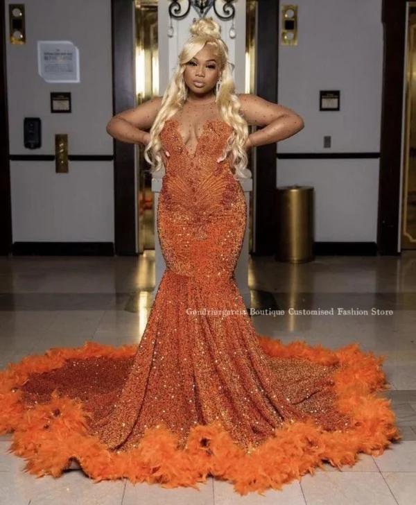 Orange prom dresseswith sheer mesh, diamond beads, and feathers